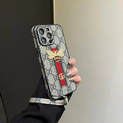 Detailed view of the Gucci logo and hand strap on the luxury phone case