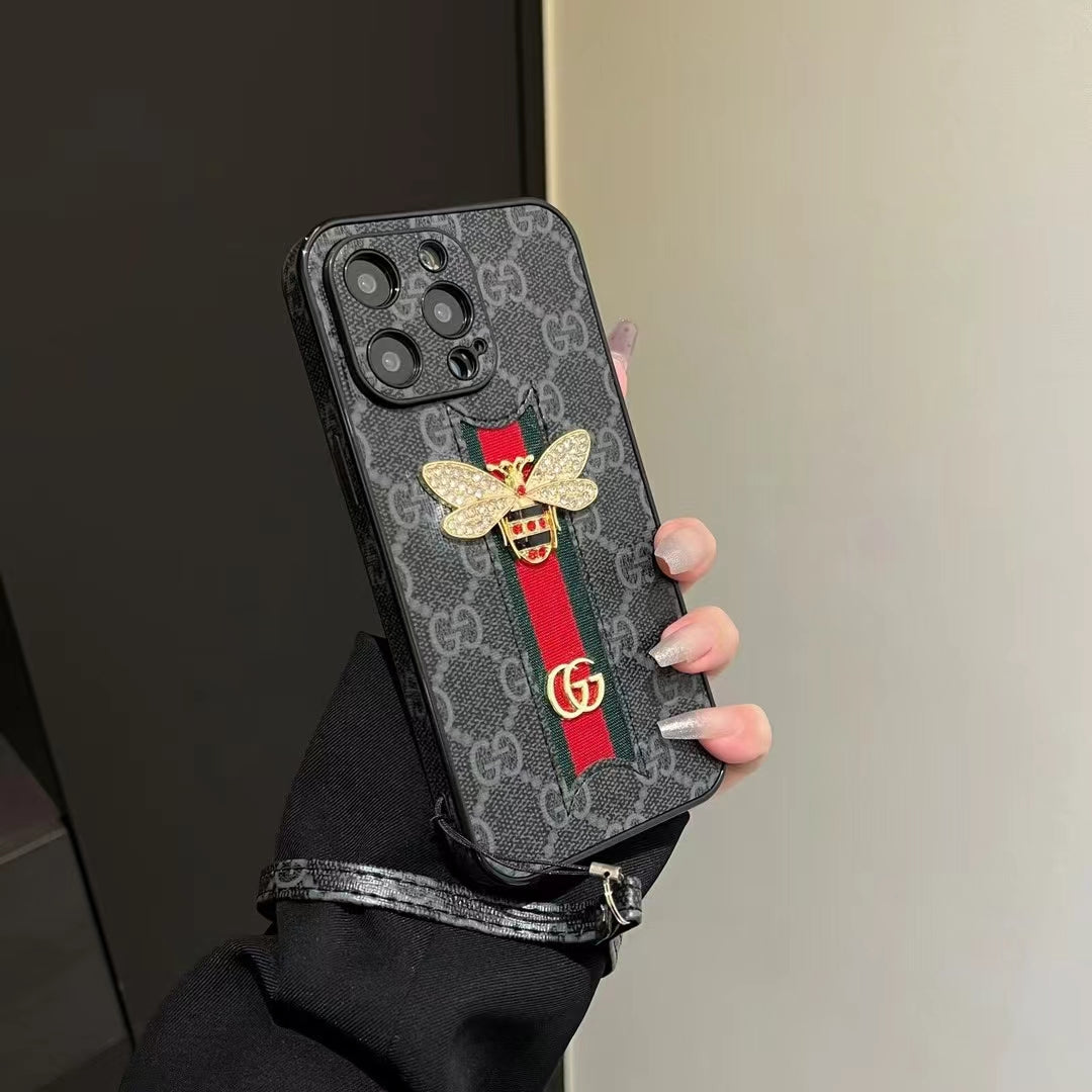 Gucci phone case with hand strap placed next to matching Gucci accessories