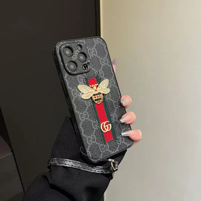 Gucci phone case with hand strap placed next to matching Gucci accessories