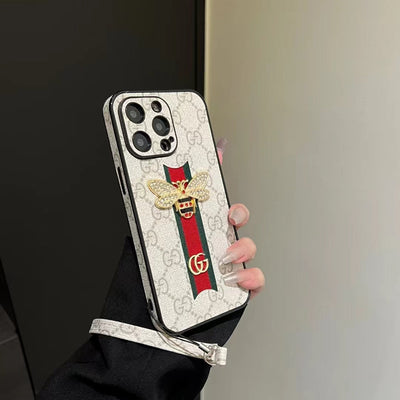 Gucci phone case with hand strap placed next to matching Gucci accessories