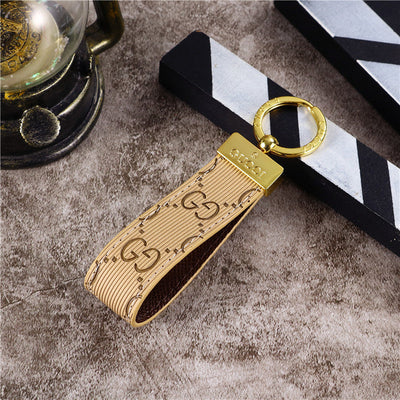 Gucci Keychain featuring the iconic logo and luxurious design, displayed against a neutral backdro