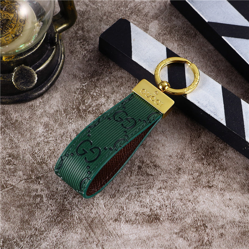 Gucci Keychain featuring the iconic logo and luxurious design, displayed against a neutral backdro